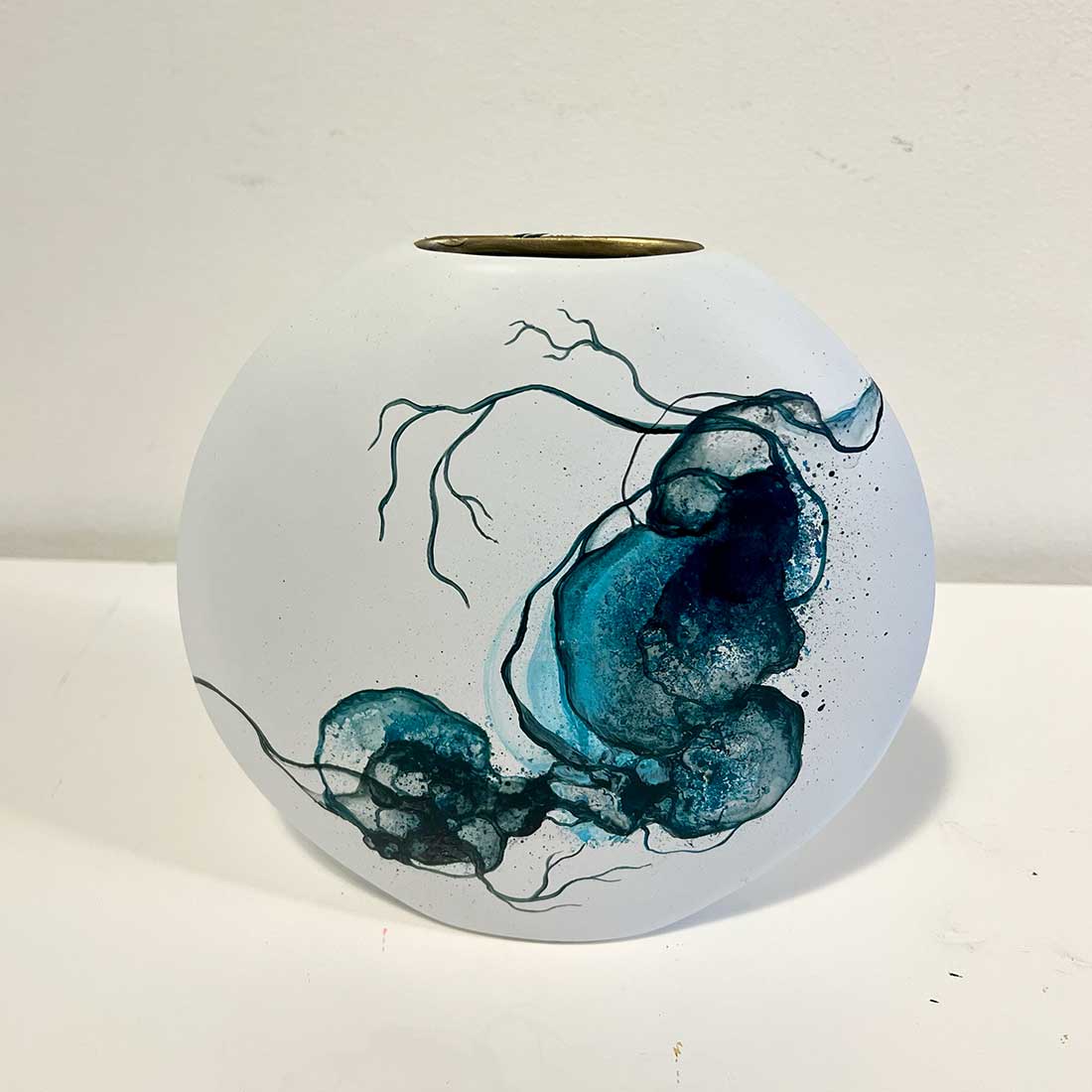 Hvid vase med abstrakt kunst i blå. Kunstner Rikke Darling